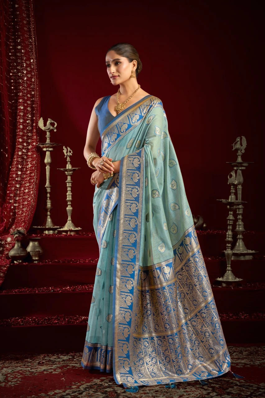 Woman wearing a light blue saree with a red background